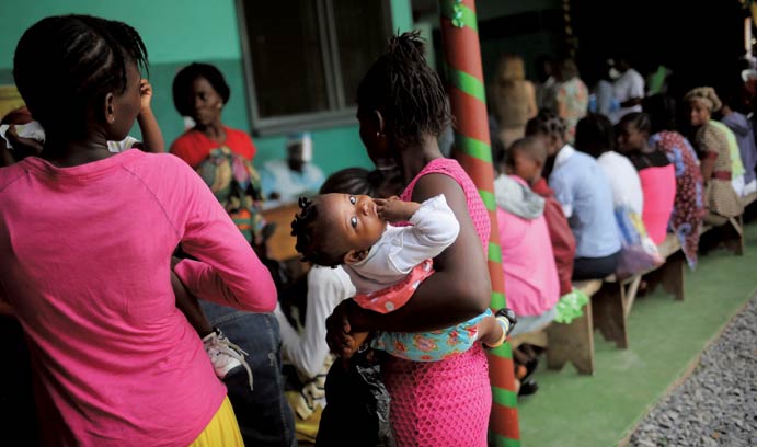 Mother bringing her sick child for treatment in Liberia during 2015 Ebola outbreak